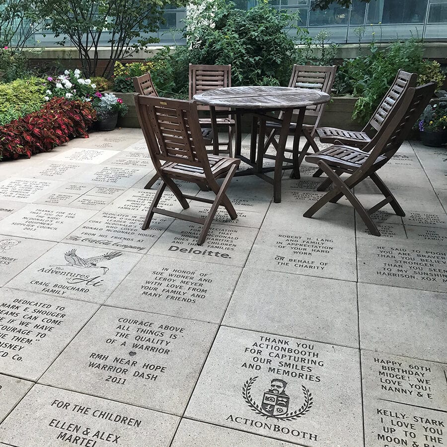Patio with picnic table and many inscribed bricks with messages from families and donors