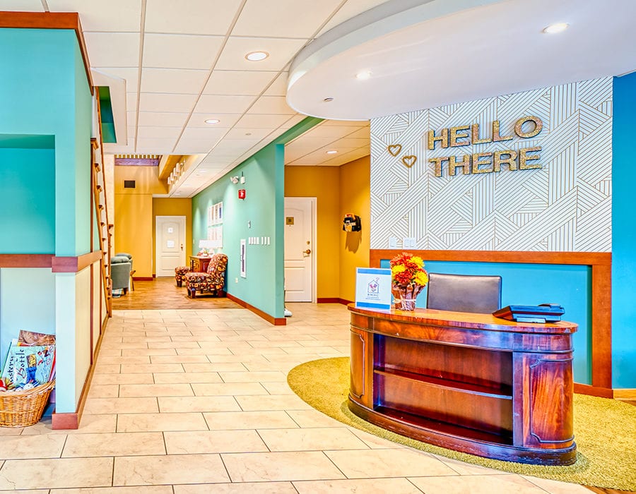 Reception desk in a house with a sign on the wallthat says "Hello there."