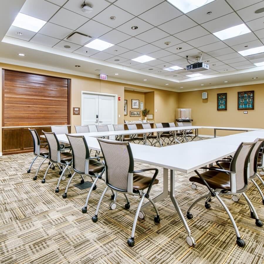 Conference room with tables and chairs laid out in a rectangle.